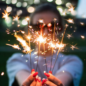 Close-up of a 10-inch gold sparkler emitting bright golden sparks, creating a festive atmosphere for celebrations and events.
