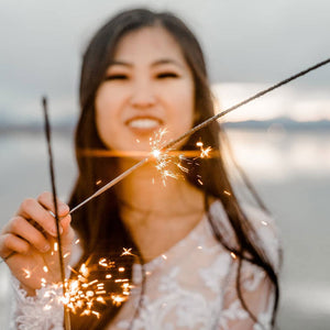 "Lady holding 20-inch low smoke wedding sparklers, creating an enchanting ambiance with minimal smoke and vibrant golden sparks."