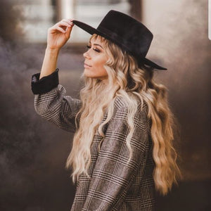 Lady wearing black hat with large billows of black smoke coming from black smoke bomb in background