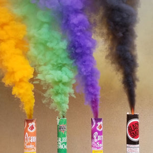 Halloween smoke bombs producing clouds of orange smoke, green smoke, purple smoke and black smoke