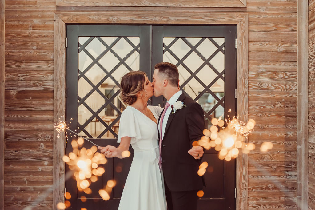 Man and woman holding long sparklers for wedding