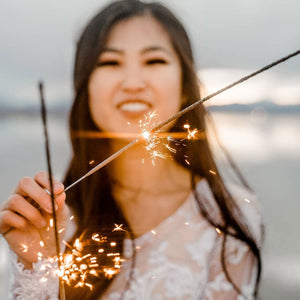 Asian lady holding two 20 inch extra long sparklers for wedding sendoff